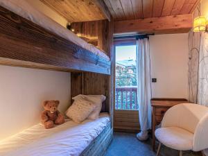 a teddy bear sitting on a bed in a bedroom at Appartement Val-d'Isère, 5 pièces, 8 personnes - FR-1-694-305 in Val-d'Isère