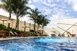 una gran piscina con sillas y sombrillas en Lidotel Valencia, en Valencia