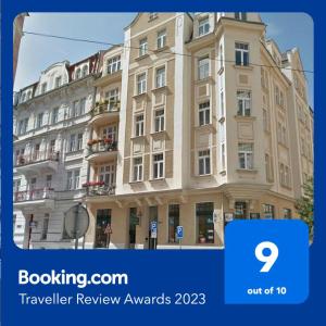 duży budynek z niebieskim znakiem przed nim w obiekcie Holiday Apartments w Karlowych Warach