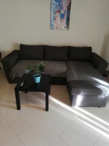 a living room with a black couch and a table at Apartment by the beach - Nei Epivates in Neoi Epivates