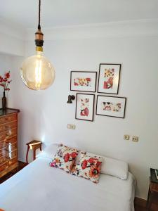 a bedroom with a white bed and pictures on the wall at Spacious Confortable near Beach Pintxos Area in San Sebastián