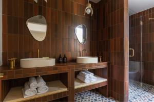 ein Badezimmer mit zwei Waschbecken, zwei Spiegeln und Handtüchern in der Unterkunft Eastwind Hotel Lake Placid in Lake Placid