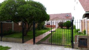 een zwart hek voor een tuin met een huis bij Casa planta baja en Faro Mogotes in Mar del Plata