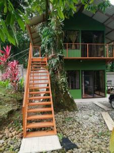 a wooden staircase leading to a house with a tree at Villas Cacao in Fortuna