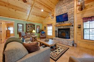 a living room with a couch and a fireplace at Broken Bow Cabin with Hot Tub and Deck - 4 Mi to Lake! in Broken Bow