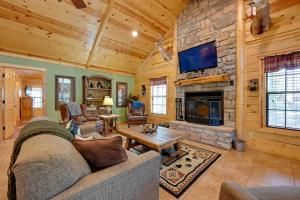a living room with a couch and a fireplace at Lavish Cabin Hot Tub and Deck, Near Broken Bow Lake in Broken Bow