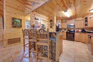 a kitchen with a center island in a log cabin at Lavish Cabin Hot Tub and Deck, Near Broken Bow Lake in Broken Bow