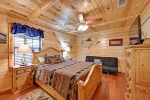 a bedroom with a bed and a ceiling fan at Lavish Cabin Hot Tub and Deck, Near Broken Bow Lake in Broken Bow