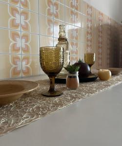 a wine glass sitting on a counter in a bathroom at "In viaggio come a casa" vicino alla Stazione, LTScalo! in Monticchio