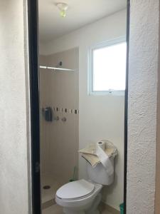 a bathroom with a white toilet and a window at Casa Meneses in Sanctórum