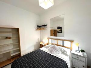 1 dormitorio con cama y espejo en la pared en ALCAMAR Habitaciones en Pisos compartidos cerca al Mar!, en Alcalá
