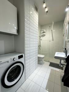 a white bathroom with a washing machine in it at Apartament Szczecin in Szczecin