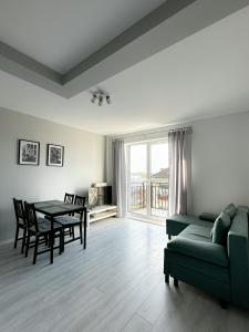 - un salon avec un canapé vert et une table dans l'établissement Apartament Szczecin, à Szczecin