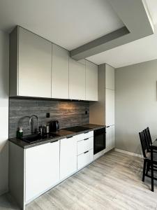 a kitchen with white cabinets and a sink at Apartament Szczecin in Szczecin