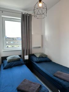 - 2 lits dans une chambre avec fenêtre dans l'établissement Apartament Szczecin, à Szczecin