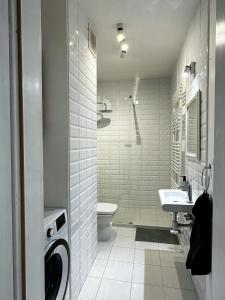 a white bathroom with a toilet and a sink at Apartament Szczecin in Szczecin