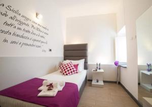 カターニアにあるPalazzo Sisto Exclusive Roomsのベッドルーム1室(ベッド1台、タオル2枚付)