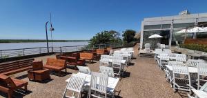a row of white chairs and tables next to the water at Loft Espectacular Céntrico con Garaje in Rosario