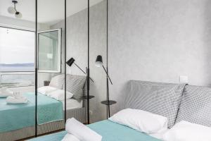 a bedroom with two beds and a mirror at Apartment ABIA Žnjan in Split