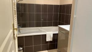a bathroom with a bath tub and a sink at F50 Ferme de Deauville 1 CH rez-de-jardin avec escalier in Saint-Arnoult +9 photos