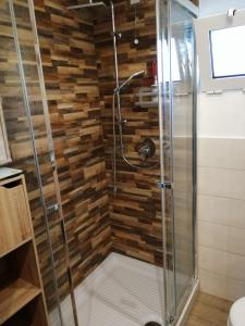 y baño con ducha y pared de madera. en Welcome Migliarina, en La Spezia