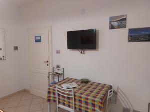 una stanza con un tavolo e una TV su una parete di Grazioso Monolocale Bellagio a Bellagio