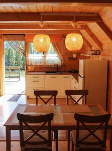 サシノにあるAgroturystyka "Trzy Dęby" w Sasinieのキッチン(テーブル、椅子、冷蔵庫付)