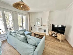 un soggiorno con divano blu e TV a schermo piatto di Le plage de Notre-Dame - Appartement au coeur de la vieille ville a Boulogne-sur-Mer