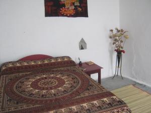 a bedroom with a bed and a table with a rug at Indian Homestay in Khajurāho