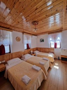 two beds in a room with wooden ceilings at Hotel Domino in Gjirokastër