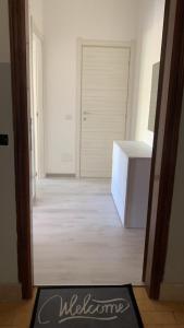 einen Flur mit einer weißen Tür und einem weißen Kühlschrank in der Unterkunft Casa Mare Calle in Casa Borgorosso