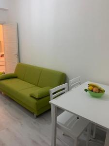 sala de estar con sofá verde y mesa en Casa Mare Calle en Casa Borgorosso