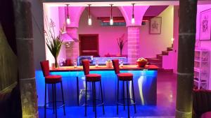a kitchen with a bar with red stools at Riad Kalaa 2 in Rabat