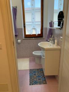 ein Badezimmer mit einem Waschbecken, einem WC und einem Spiegel in der Unterkunft Casa Mare Calle in Casa Borgorosso