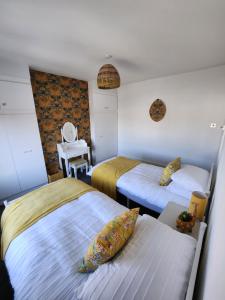 Un dormitorio con 2 camas y una silla. en Delightful newly renovated 3-bed house with garden beach hut en Blackpool
