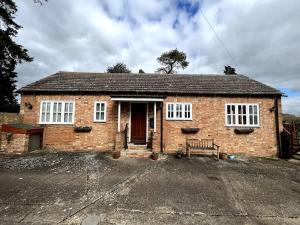 a brick house with a bench in front of it at The Annexe at Firs House in Bedford