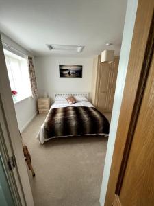 un dormitorio con una cama con una persona puesta en ella en The Annexe at Firs House, en Bedford
