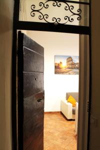 una puerta que conduce a una sala de estar con sofá en 50 Passi Colosseo Apartment en Roma