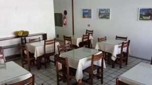 a dining room with tables and chairs in a restaurant at Hotel Gaivota in Recife