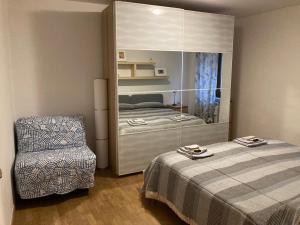 a bedroom with a bed and a chair and a mirror at Casa Vacanze Mary in Orvieto