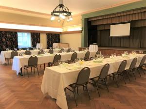 Gasthaus zum Goldenen Kreuz في Rafz: قاعة اجتماعات مع طاولات وكراسي وشاشة