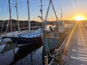 two boats are docked in a marina at sunset at The Old Boathouse at Bunbeg Harbour in Bunbeg