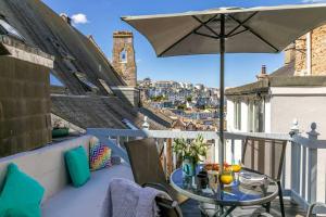 a balcony with a table and an umbrella at Family Tides Brixham in Brixham