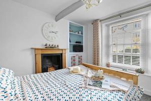 a bedroom with a bed and a clock on the wall at Family Tides Brixham in Brixham