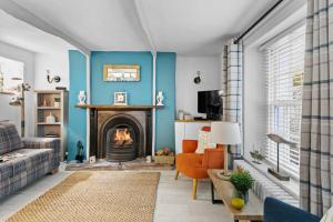 a living room with a fireplace and a couch at Family Tides Brixham in Brixham
