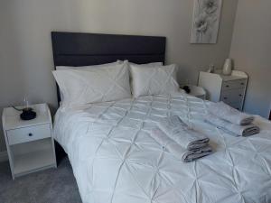 een wit bed met twee handdoeken erop bij Bellman 12, Newly Refurbished 2023, Lake View, Pet Friendly in Bowness-on-Windermere