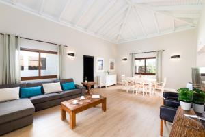 a living room with a couch and a table at Villa Caleta Del Sol by Villa Plus in Caleta De Fuste