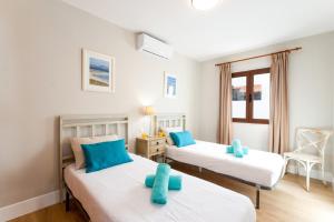 - une chambre avec 2 lits dotés d'oreillers bleus dans l'établissement Villa Caleta Del Sol by Villa Plus, à Caleta de Fuste