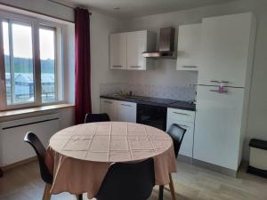 een keuken met een tafel en stoelen en een keuken met een raam bij appartement 40 m² proche rempart in Langres