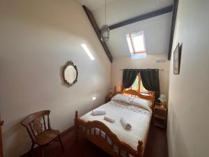 a bedroom with a bed with a mirror and a chair at 4 beautiful stone built barns sleeping 17 people in Llangwm-isaf